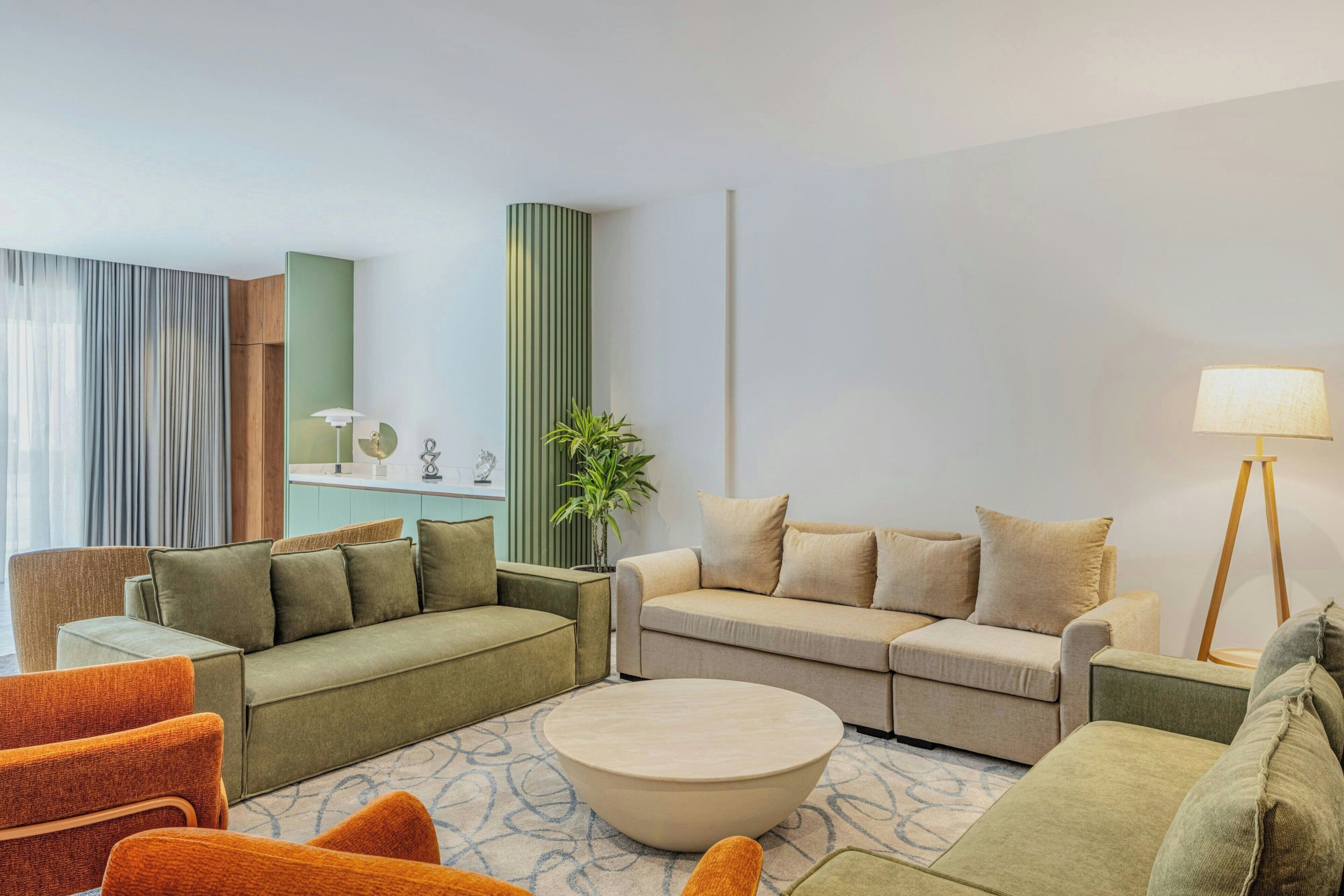 A modern living room with a sofa set, a coffee table, and a lamp.