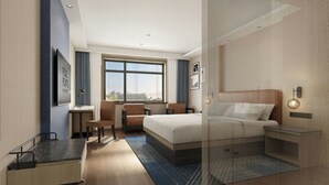 Ein modernes Hotelzimmer mit Bett, Schreibtisch, Stuhl und einem großen Fenster.