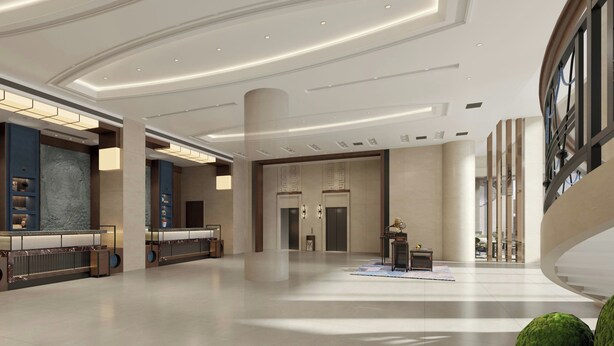 Eine geräumige Lobby mit einer zentralen Säule, einem Empfangstresen und einem großen Fenster.