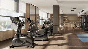 Ein modernes Fitnessstudio mit Ergometer, Laufbändern und einem Krafttrainingsbereich.