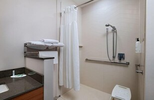 A bathroom with a shower, a toilet, a sink, and a towel rack.