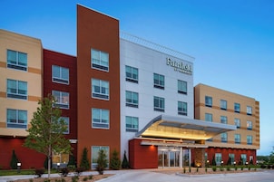 Um hotel Fairfield by Marriott de vários andares com design moderno, apresentando uma entrada destacada com galeria coberta.