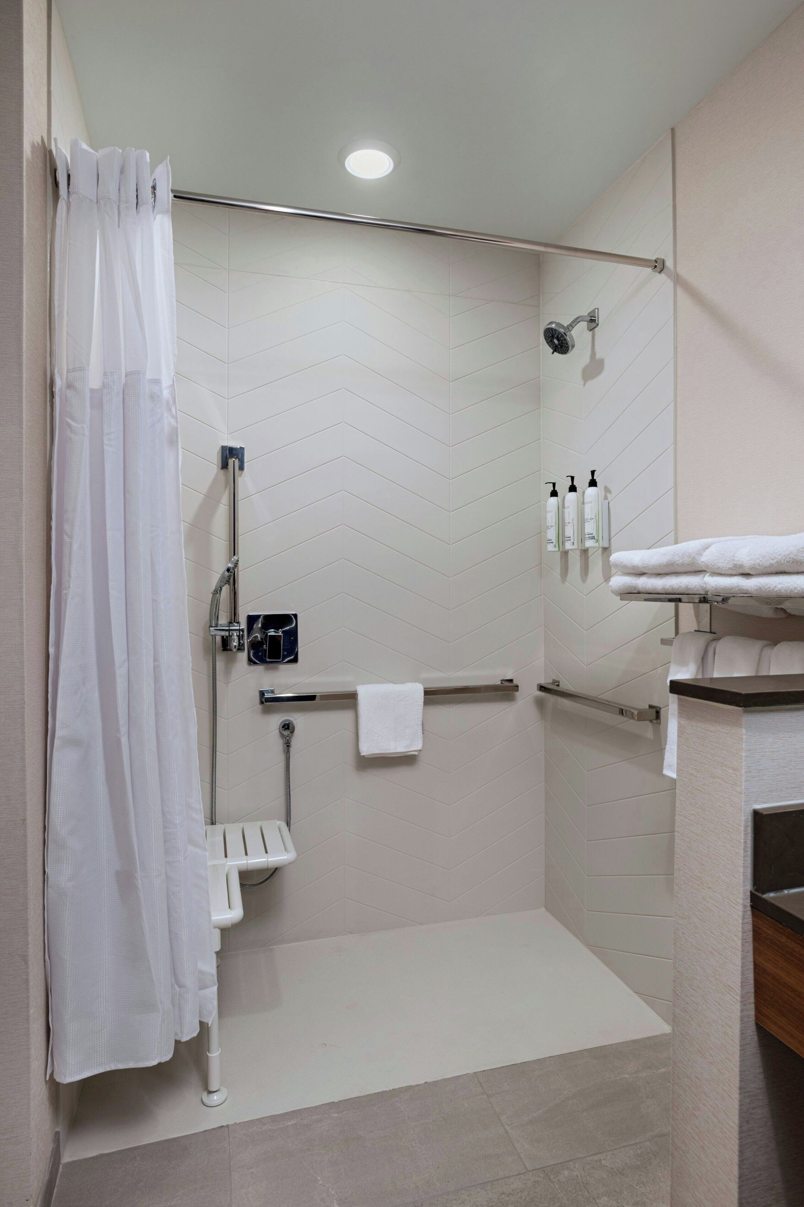 A modern bathroom with a shower, toilet, and sink.