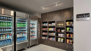 A grocery store interior with refrigerated beverage dispensers, snack shelves, and a sign reading "the market". - Residence Inn By Marriott Paso Robles (Paso Robles)