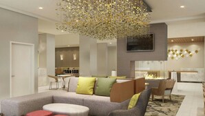 A modern living room with a sectional sofa, red ottomans, and a fireplace. - Residence Inn By Marriott Paso Robles (Paso Robles)