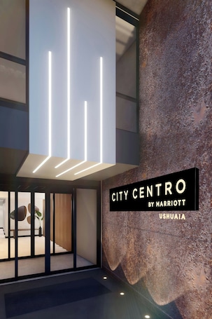A modern interior with a stone wall and a sign reading "CITY CENTRO BY MARRIOTT USHUAIA".