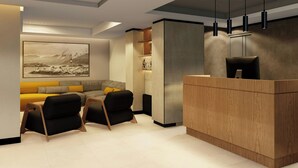 A modern reception area with a wooden desk, black chairs, a large framed artwork on the wall, and a built-in shelving unit. - City Centro By Marriott Ushuaia Argentina (Ushuaia)