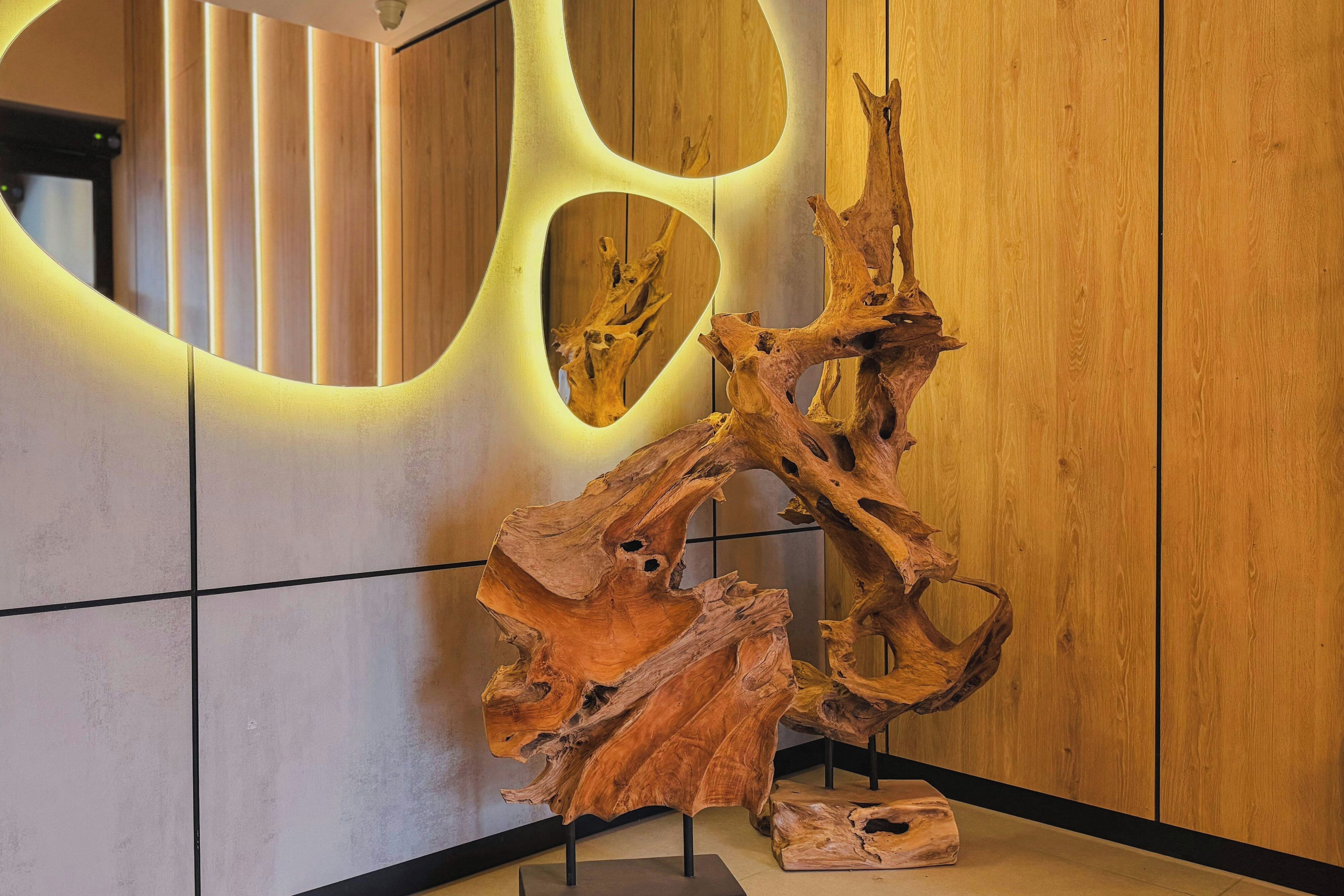A modern interior with a wooden wall and abstract art pieces.