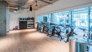 A gym with exercise bikes, a kettlebell, and a large window. - 2210 Kenect  (Phoenix)