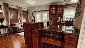 A spacious kitchen with a central island, wooden cabinets, and a wine rack. - Delightful 3-bedroom 2-bathroom Single family home in Springfield (Springfield)