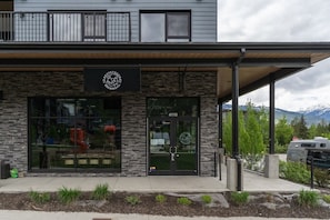 Un bâtiment moderne avec une façade en pierre, de grandes fenêtres et une enseigne indiquant « Revvystock Brewing Co. ».