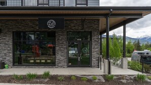 A modern building with a stone facade, large windows, and a sign for Revvystock Brewing Co. - That 70s Chalet in the Mackenzie Village (Revelstoke)