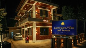 Un hotel de varios pisos con un cartel llamativo de Glitz Hotels, Villas and Resorts.