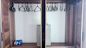 Un armadio in legno con anta a specchio, un appendiabiti e una panca contenitore.
