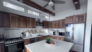 Una cucina moderna con mobili in legno, elettrodomestici in acciaio inossidabile e un'isola centrale.
