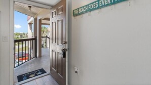 Een hotelingang met een deur die uitkomt op een balkon.