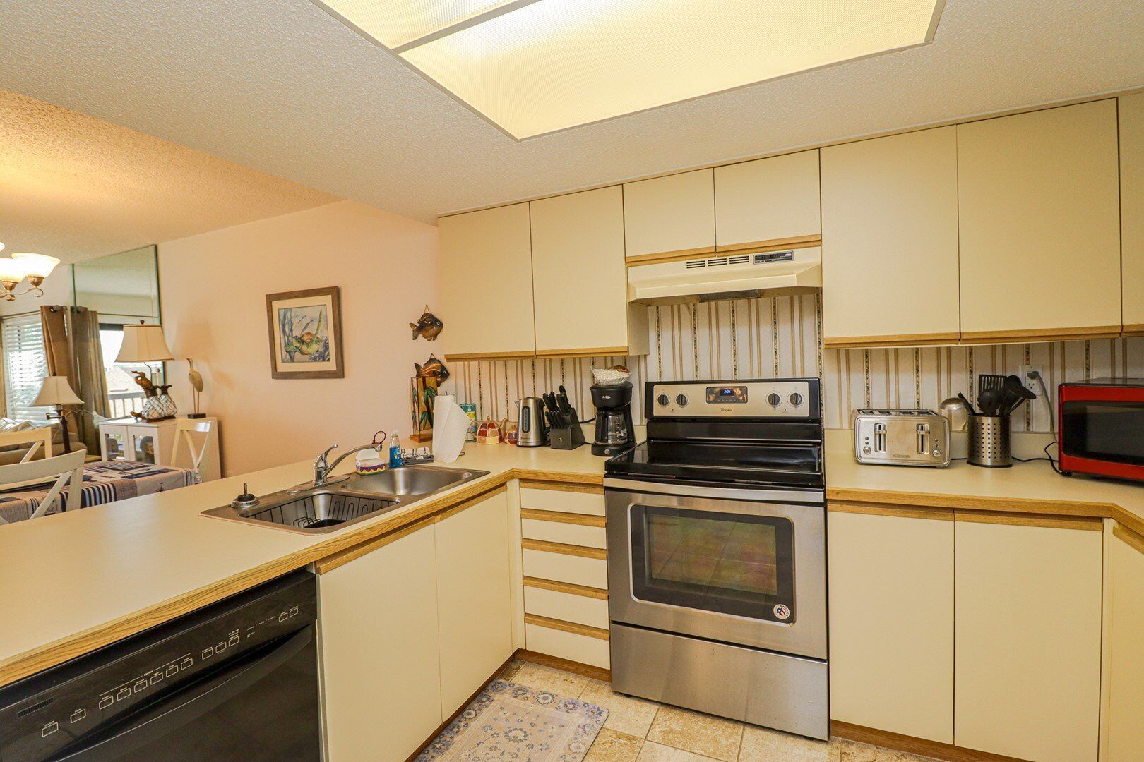 A compact kitchen with a dishwasher, stove, and toaster.