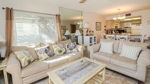 Ein Wohnzimmer mit zwei Sofas, einem Couchtisch und einem Deckenventilator.