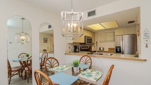 Una cocina moderna con electrodomésticos de acero inoxidable, una isla central y una lámpara colgante.