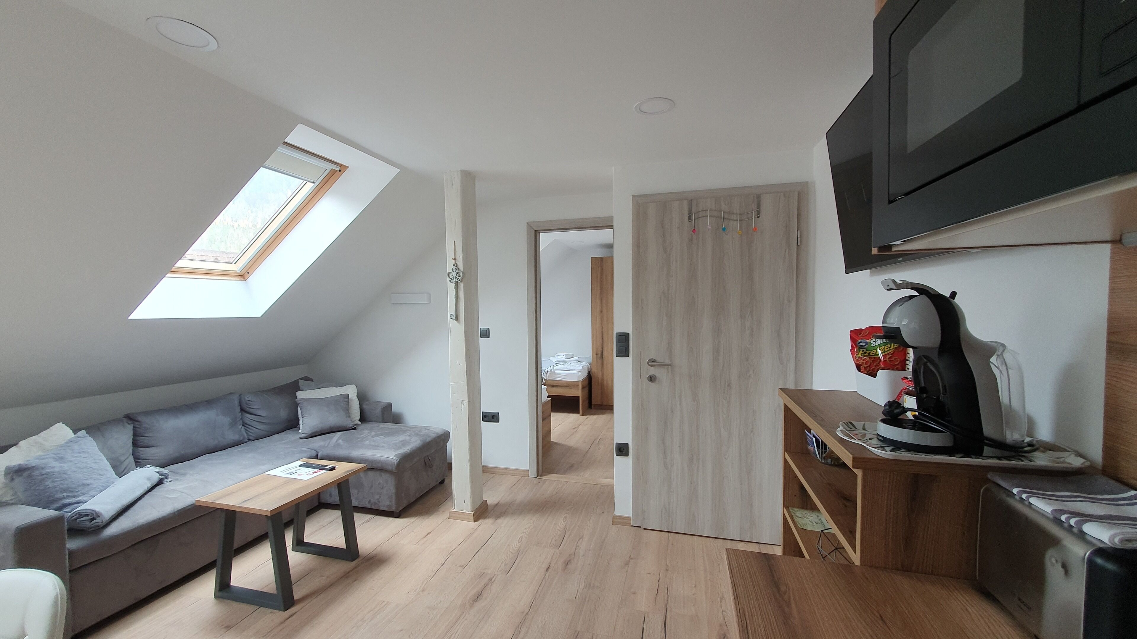 Een knus woongedeelte met een slaapverdieping, een bank, een eettafeltje, een kitchenette en een televisie.