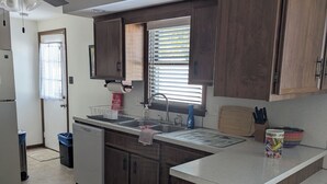 A modern kitchen with wooden cabinets, a built-in sink, and a ceiling fan. - Spacious Frederick County Retreat (Middletown)