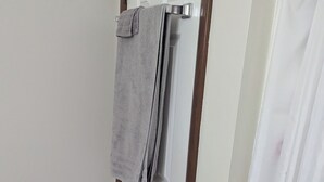 A bathroom with a white door, a towel hanging on a towel rack, and a shower curtain with cartoon characters. - Spacious Frederick County Retreat (Middletown)
