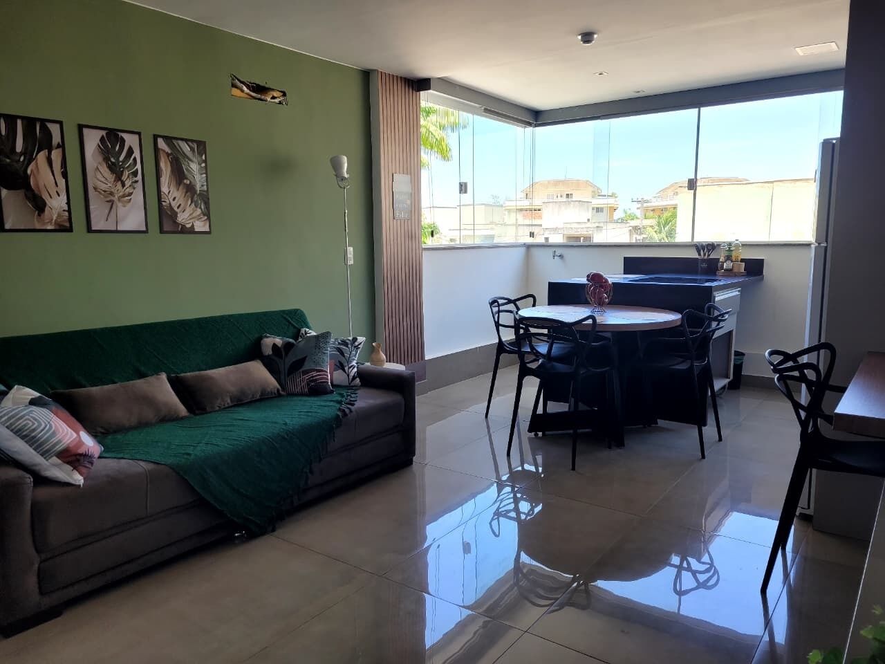 Una sala de estar con un sofá, una mesa de comedor con sillas y una zona de cocina.