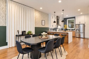 A modern kitchen with a central island, wooden cabinets, and stainless steel appliances. - Hot Tub Game Room 20 Beds & Bunk Room 3500sqft (Nashville)