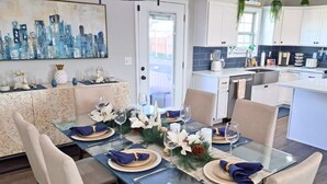 Un coin repas avec une table en verre, dressée pour six personnes, entourée de chaises de couleur beige.