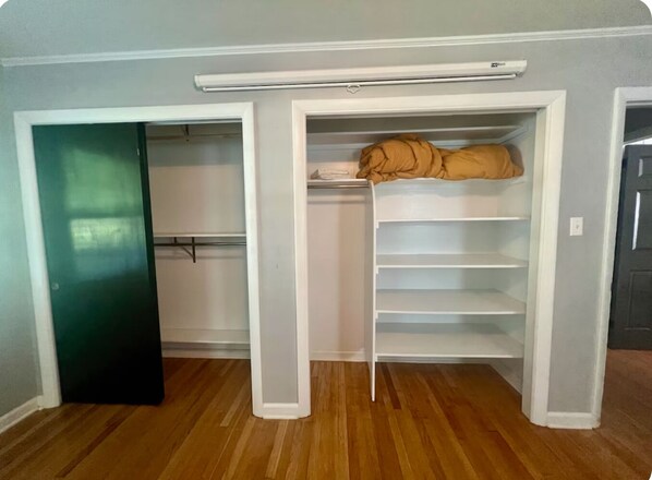 Une pièce avec un placard intégré, un lit et une porte.