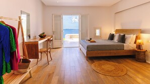 Un dormitorio con cama, escritorio y vista al mar.