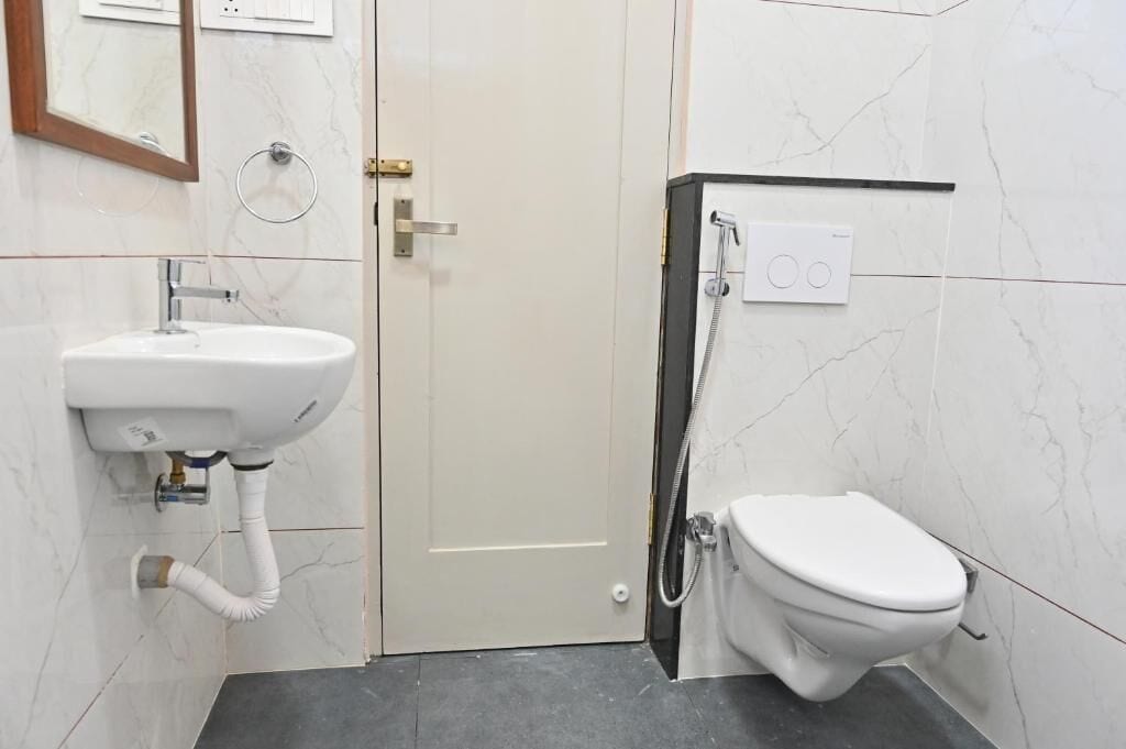 A bathroom with a white sink, toilet, and shower.