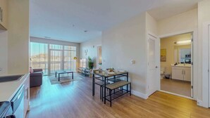 A spacious living area with a dining table, sofa, and a view through large windows. - Great Charming stay (Stamford)