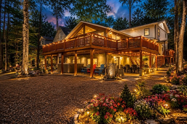 A two-story lodge with a covered deck and outdoor seating area.