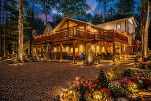 Un chalet à deux étages doté d’une terrasse couverte et d’un espace salon extérieur.