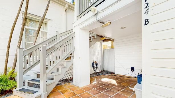 Un edificio bianco con una scala che conduce al secondo piano.
