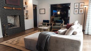 Una sala de estar con chimenea, un sofá, una mesa de centro y una televisión al fondo.