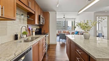Una cocina moderna con armarios de madera, electrodomésticos de acero inoxidable y encimera de mármol.