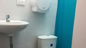 Ένα μπάνιο με έναν λευκό νιπτήρα, μια τουαλέτα και έναν στεγνωτήρα χεριών.