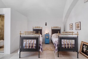 A bedroom with two beds, a nightstand, a wall-mounted light, and framed artwork. - Room 'Nardo House: Matteotti Suite' with Shared Terrace, Wi-Fi and Air Conditioning (Nardò)