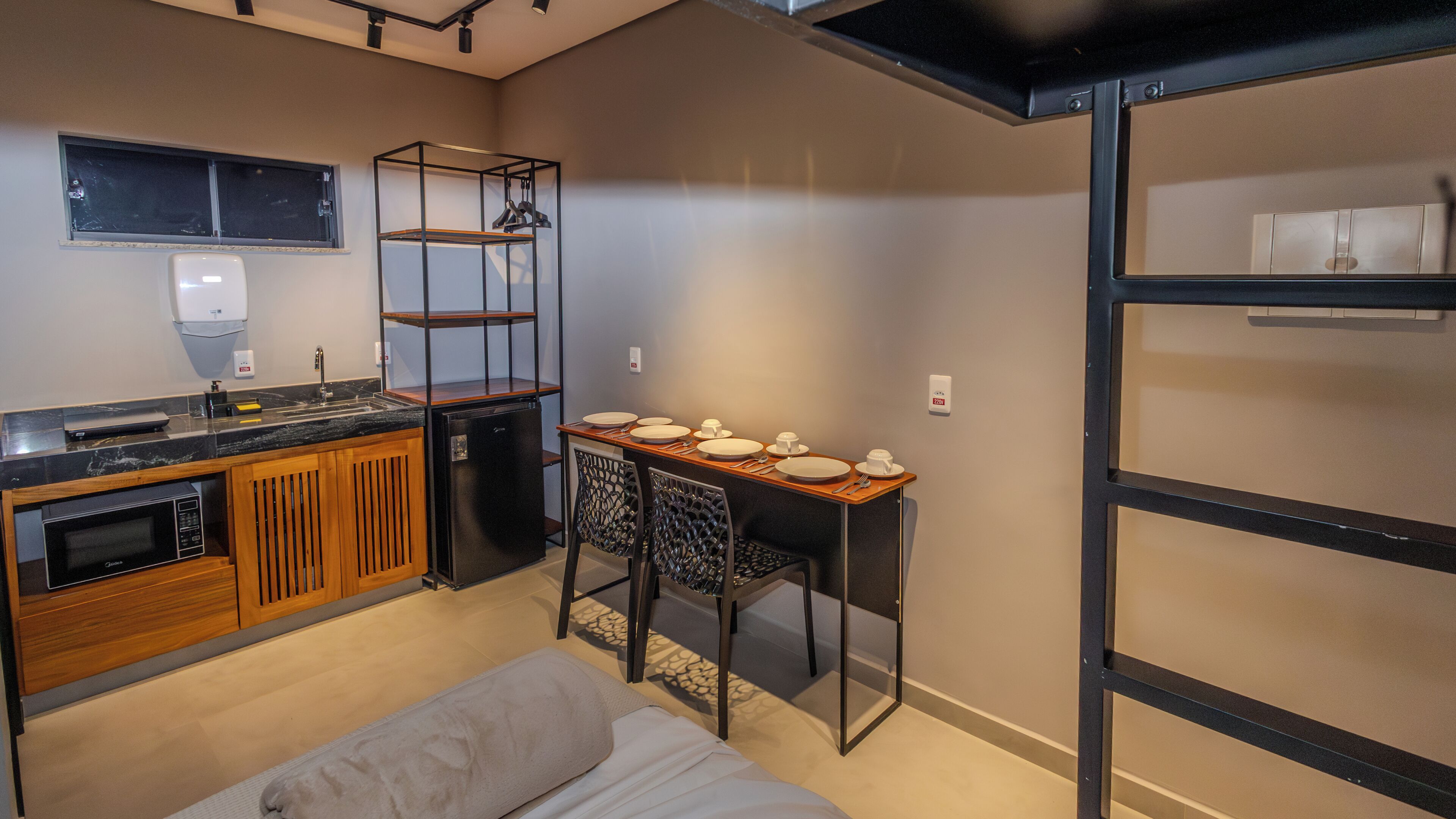 A compact kitchen with a refrigerator, microwave, and wooden cabinets.