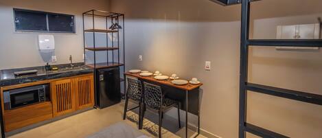 A compact kitchen with a refrigerator, microwave, and wooden cabinets.
