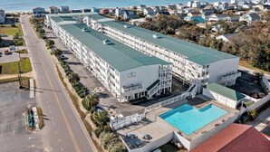Et hotel med flere etager og swimmingpool, beliggende i nærheden af en strand.