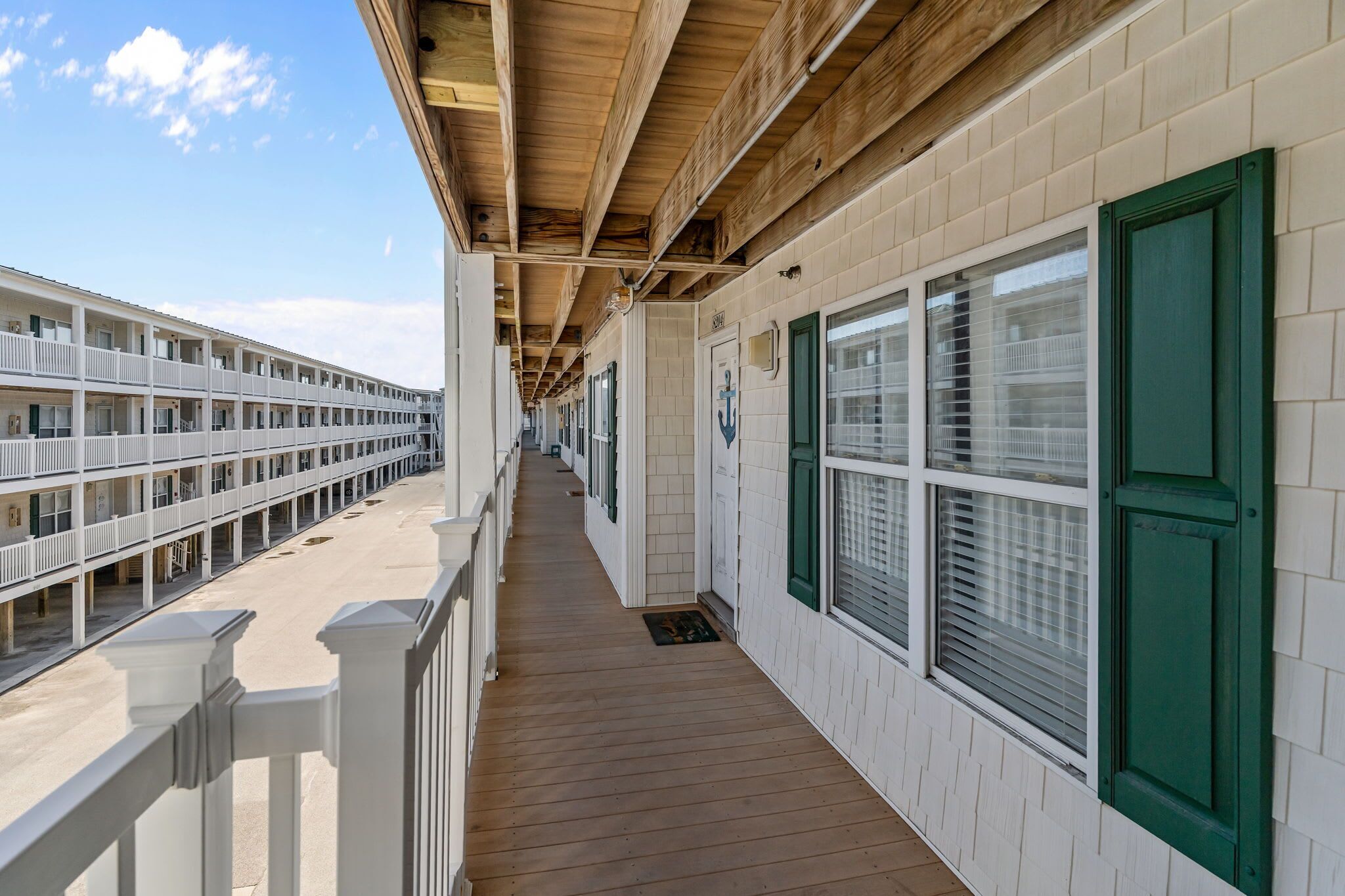 A long corridor with multiple rooms, each with a window and a door.