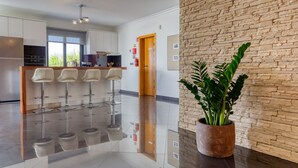 Una cocina moderna con electrodomésticos de acero inoxidable, una barra con taburetes y una pared de acento de piedra.