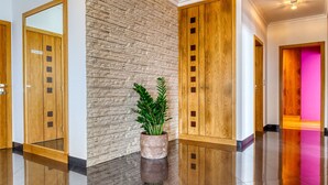 Un vestíbulo elegante con pared de piedra, puertas de madera y una planta en maceta.