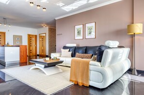 A modern living room with a sofa, coffee table, and a lamp. - Oasis do Sol, a Home in Madeira (Ponta do Sol)