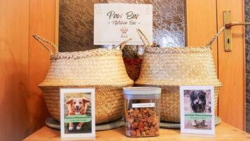 Un présentoir en bois avec deux paniers en osier, une pancarte indiquant « Paw Bar - Potchen Bar », et deux photos de chiens accompagnées de légendes.