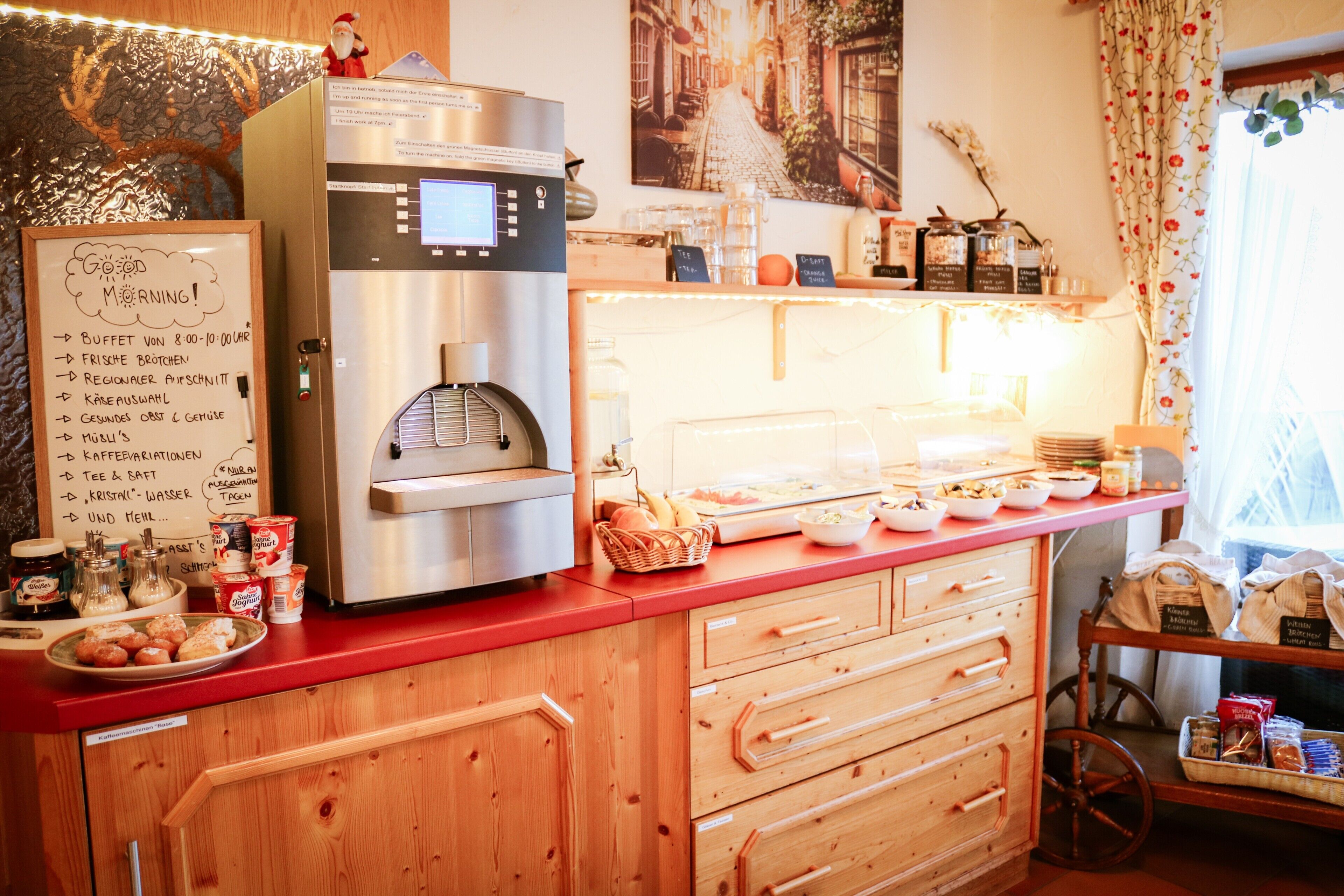 Eine Küchenarbeitsplatte mit einer Kaffeemaschine, einer Kreidetafel mit Speisekarte und verschiedenen Lebensmitteln.