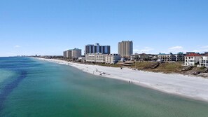 Eine Küstenstadtlandschaft mit Strand, hoch aufragenden Hotels und blauem Himmel.